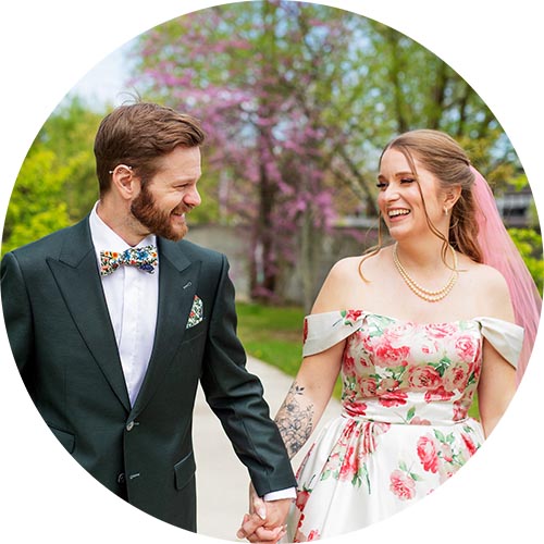 A wedding couple walking down an outdoor garden