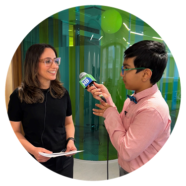 A child is holding a microphone to interview an adult