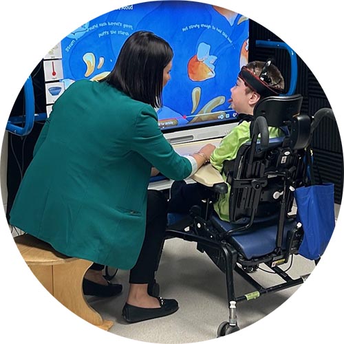 An adult is assisting a child on a special wheelchair