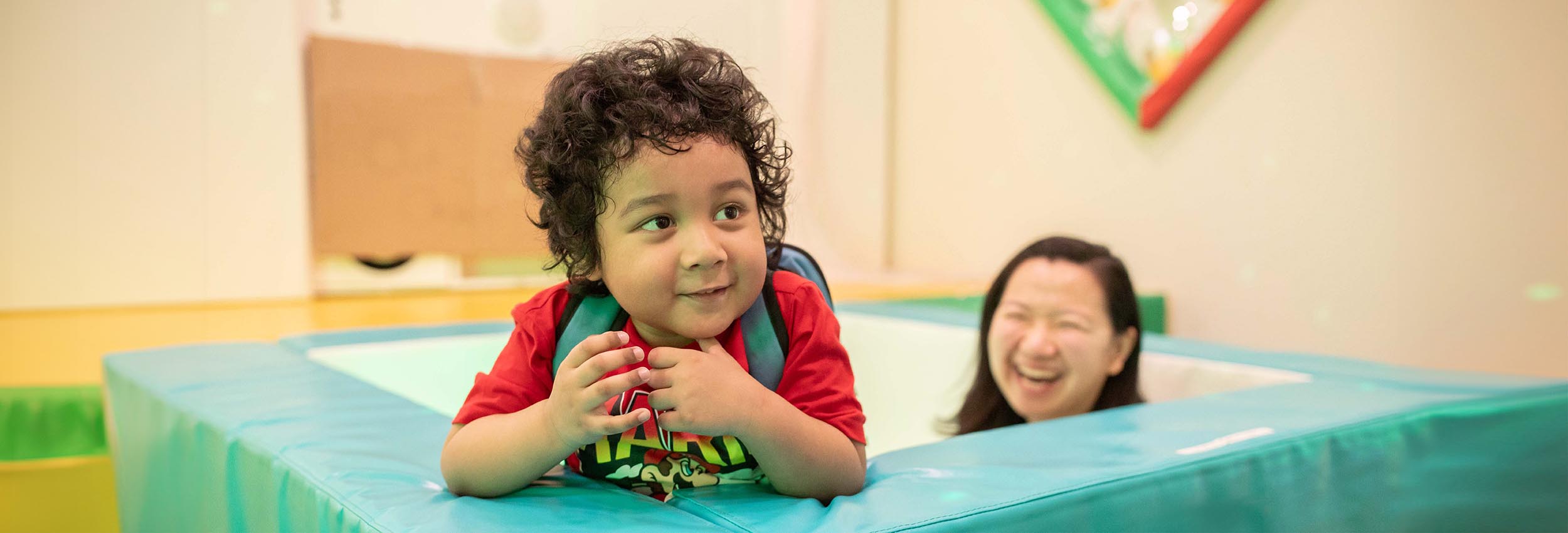 Antony, a client, peeks out of a play space in Holland Bloorview’s inpatient Snoezelen room much to the joy of Angela Lai, a therapeutic recreation assistant.